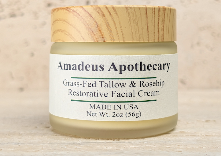 Amadeus Apothecary Grass-Fed Tallow & Rosehip Restorative Facial Cream in a frosted jar with a wooden lid.